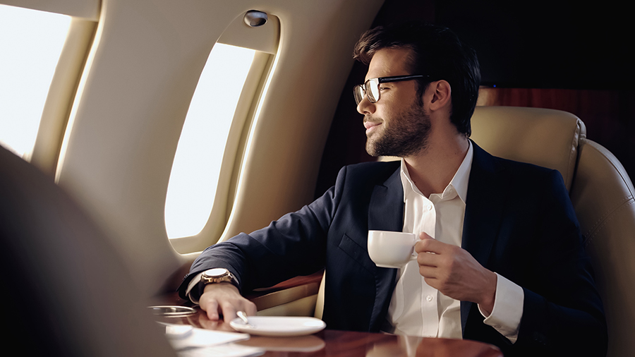 business man on private jet drinking coffee