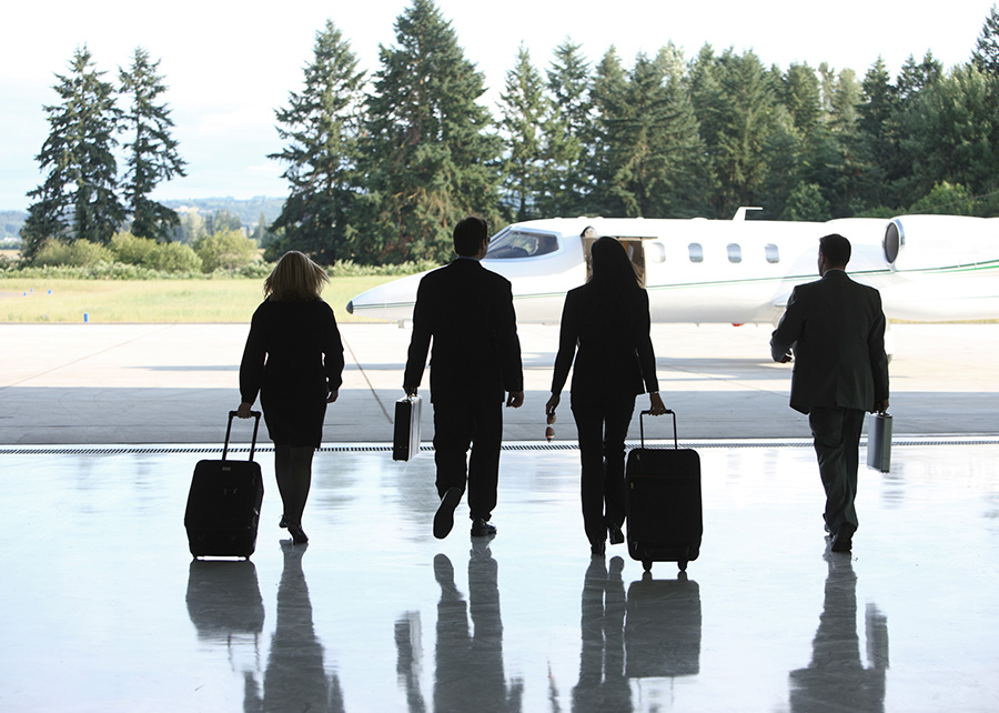 business people walking toward a private jet charter
