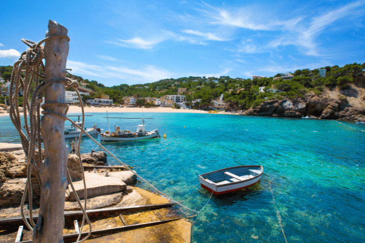 A photo of Ibiza, clear blue sea with land in the distance and some small boats
