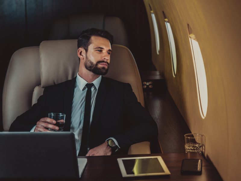 Businessman buying goods during private jet flight