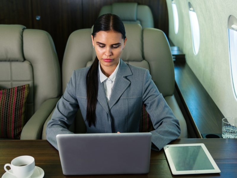 Businesswoman with laptop working in private jet