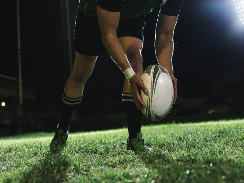 Rugby player placing a rugby ball on the pitch