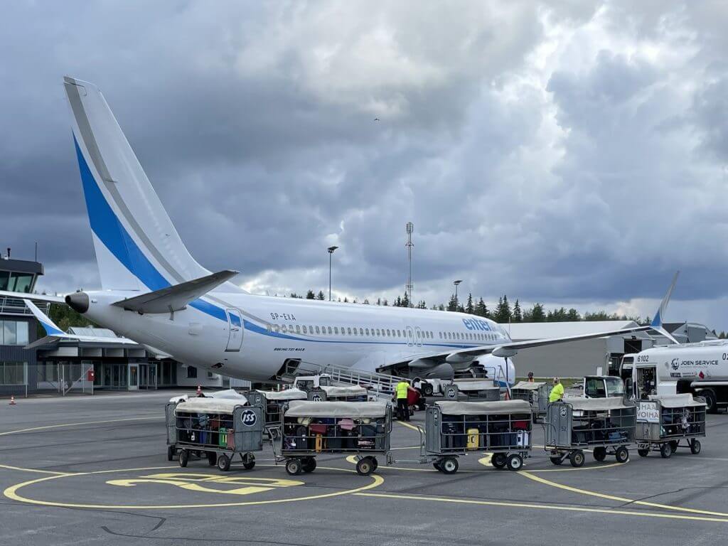 Trollies of luggage being loaded on to a plane
