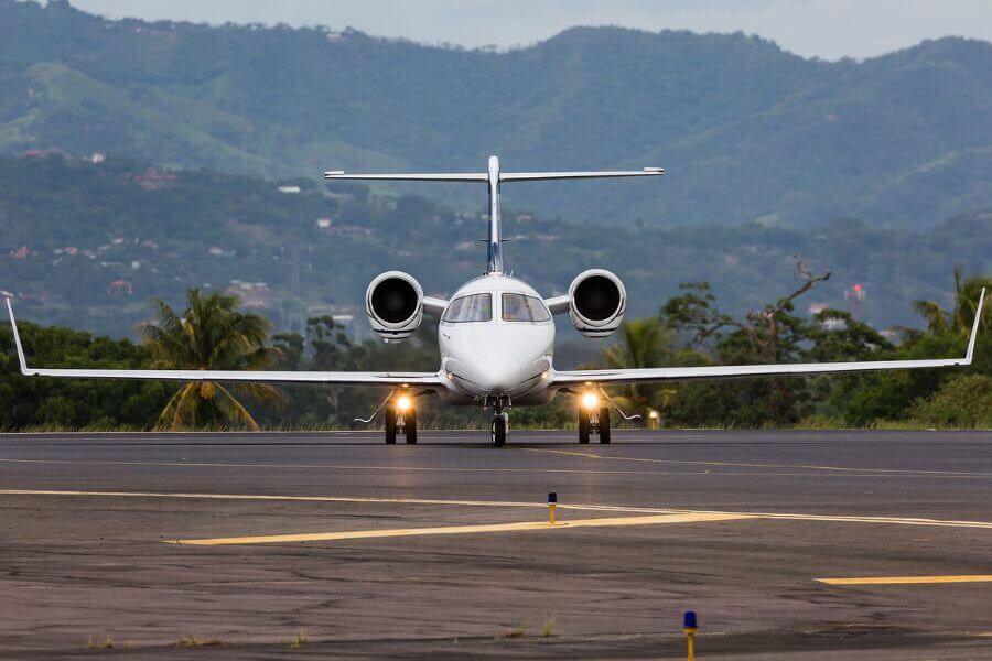 Luxury private jet flying over tropical paradise, symbolizing smart empty leg travel choices for exclusive holiday getaways